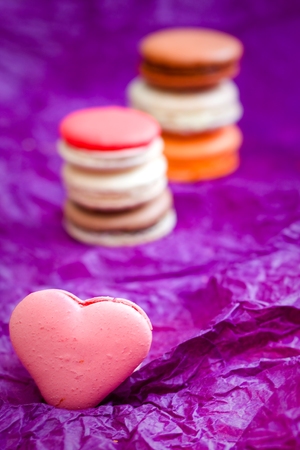 French colorful macarons with hearts on violet backgroundの写真素材