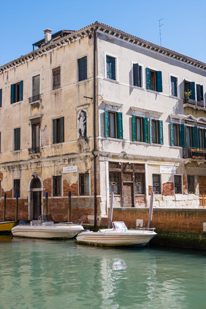 Venetian cityscape. Boats on canal and old house. Italyの写真素材