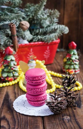 Pink macaroons with christmas decorations on wooden backgroundの写真素材