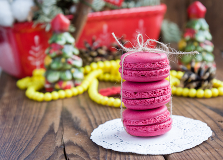 Pink macaroons with christmas decorations on woooden backgroundの写真素材