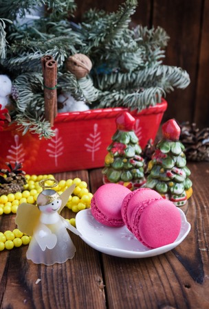 Pink macaroons with christmas decorations on wooden backgroundの写真素材