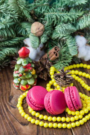 Pink macaroons with christmas decorations on woooden backgroundの写真素材