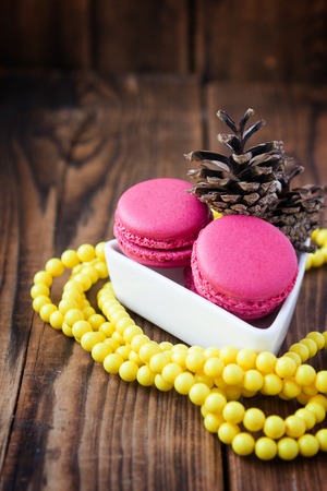 Pink macaroons with christmas decorations on woodの写真素材