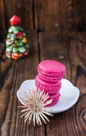 Pink macaroons with christmas decorations on woooden backgroundの写真素材