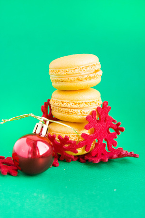 Yellow macaroons with new year decorations on green backgroundの写真素材