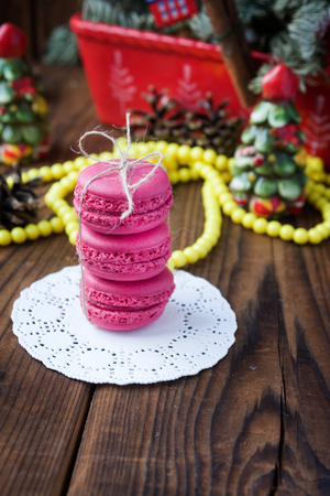 Pink macaroons with christmas decorations on woooden backgroundの写真素材
