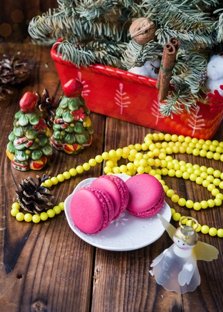 Pink macaroons with christmas decorations on woooden backgroundの写真素材