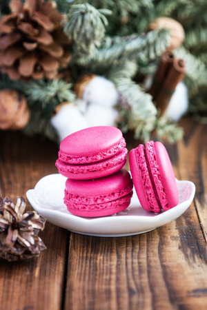 Pink macaroons with christmas decorations on woooden backgroundの写真素材