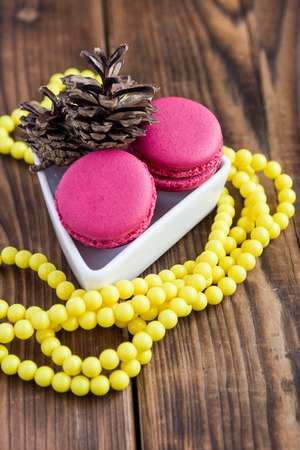 Pink macaroons with christmas decorations on woooden backgroundの写真素材