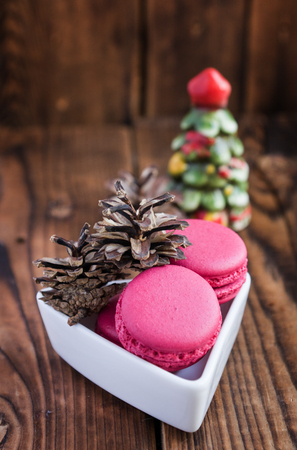 Pink macaroons with christmas decorations on woodの写真素材