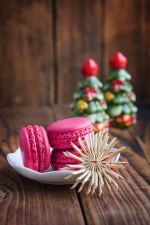 Pink macaroons with christmas decorations on woodの写真素材