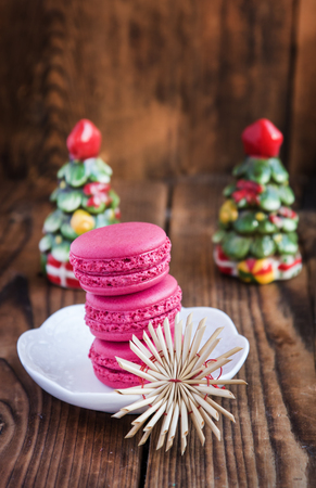 Pink macaroons with christmas decorations on woodの写真素材