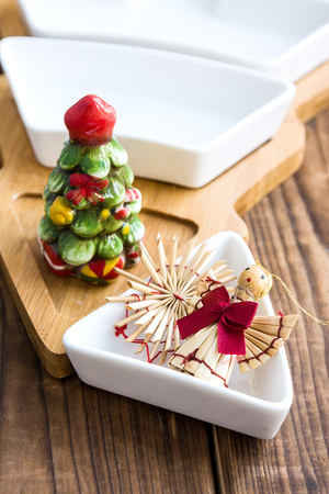 Christmas straw toys and bowl with salt shaker on woodの写真素材