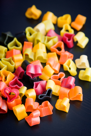 Heart-shaped pasta on black wood tableの写真素材