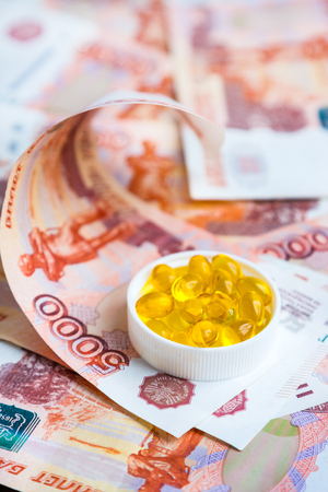 Capsules of fish oil and russian rubles on black backgroundの写真素材