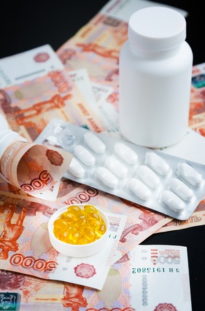 Capsules of fish oil, pills and russian rubles on blackの写真素材