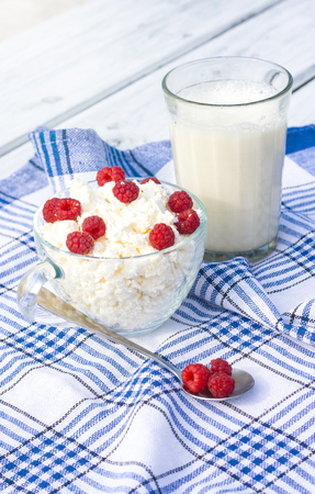 Milk and glass bowl with soft cheese and raspberryの写真素材