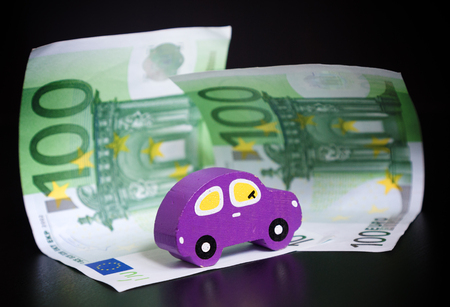 Toy car and euros on black backgroundの写真素材