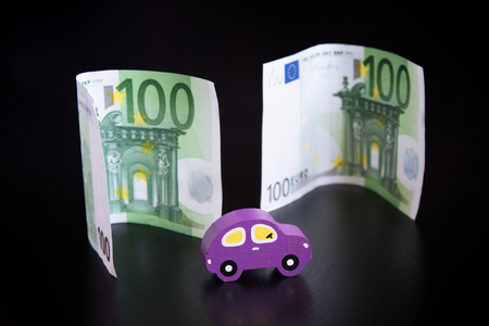 Toy car and euros on black backgroundの写真素材