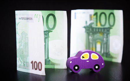 Toy car and euros on black backgroundの写真素材