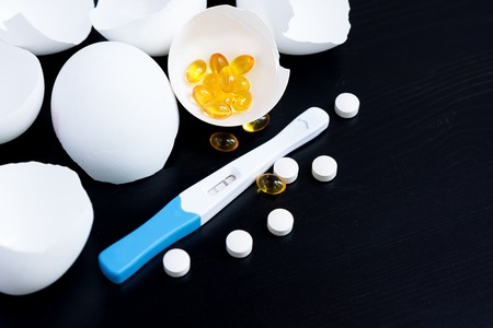 Infertility. Negative pregnancy test and eggshell on black backgroundの写真素材