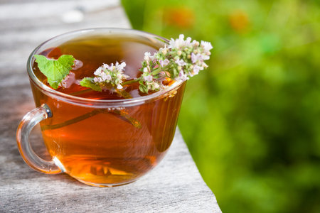 Fresh tasty hot tea with melissa outdoor in summer. Medicine healthy