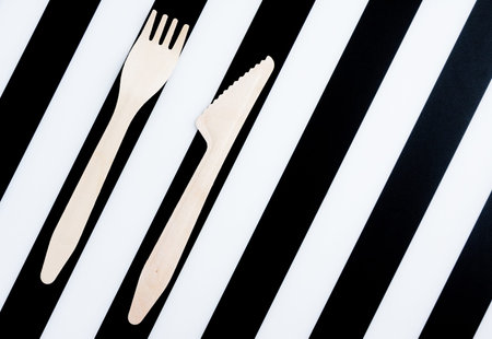 Bamboo biodegradable fork and knife made of natural eco recycle reusable material on striped...