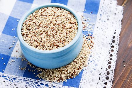 Organic quinoa grains in blue ceramic bowl, Gluten free. Concept Healthy food. Diet. Seeds of Chenopodium quinoaの写真素材