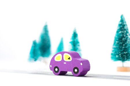 Wooden car on paper road against fir-trees on white background. Traffic on country road. Travelの写真素材