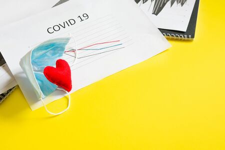 End of pandemic coronavirus and isolation. Used crumpled medical mask and felt heart on chart for reducing the incidence of morbidity and mortality. Selective focusの写真素材