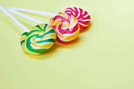Colorful lollipops on yellow background. Sweets for party. Sugar.の写真素材