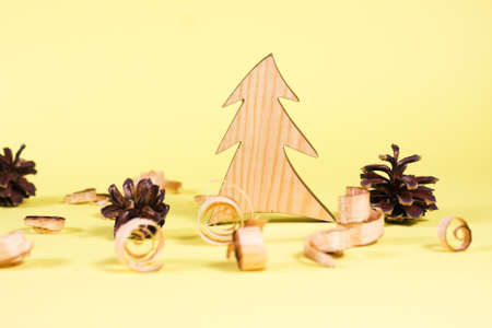 Wooden fur-tree and curled shavings on yellow backround. Eco toys. Save the forests, awareness concept. Environmentally friendly investments. Sawdust of woodworking industry. Sawmill, carpentryの写真素材
