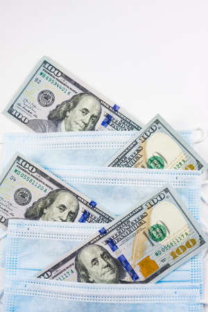 Blue medical masks and dollars.Helping poor countries with money and masks.Financial crisis due to coronavirus.Cash payments to doctors.Expensive hospital services.Sponsoring medical research.の写真素材
