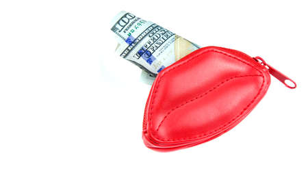 Love for money. Red purse in form of lips and banknotes of one hundred dollars. Women's salary. Selling love. Copy spaceの写真素材