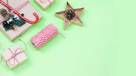 Christmas eco friendly packaging gifts on green, eco christmas holiday concept, eco decor festive winter bsnner with copy space. Present with candy and fir-tree, paer boxes and wooden tree toyの写真素材