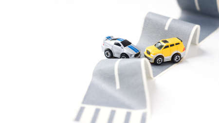 Cars accident on rough road. Two toy models on duct tape. Slippery or rough road. Insurance.の写真素材
