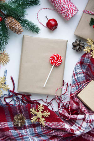Present in brown craft paper, boxes, candy, plaid and Christmas decoration on table. Copy space. Eco friendly New Year conceptの写真素材