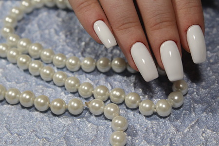beautiful white nails on a trendy texture backgroundの写真素材