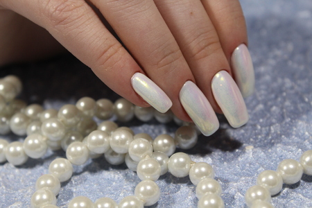 fashionable white manicure of nails on a beautiful textural backgroundの写真素材
