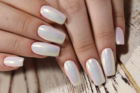 fashionable pearl manicure of nails on a beautiful textural backgroundの写真素材