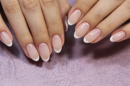 beautiful French manicure on a trendy texture backgroundの写真素材