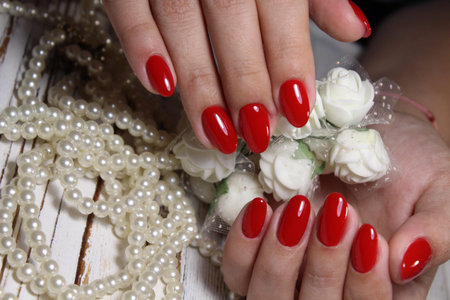 beautiful red manicure on a textured trendy backgroundの写真素材