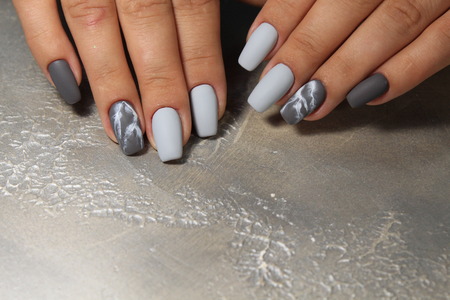 beautiful nail art manicure on the background of a fashionable textureの写真素材