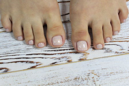 beautiful beige pedicure on a trendy texture background