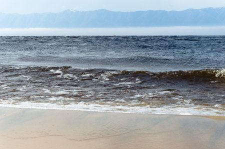 Waves on the sandy shore of the lake. Summer landscape.
