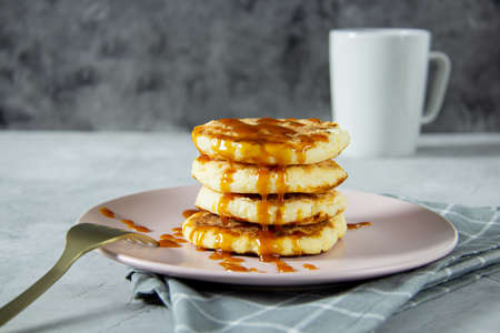 Fried cottage cheese pancakes with boiled caramel. Delicious healthy food. Dinner setting, close-upの写真素材