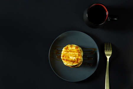 Fried curd pancakes with boiled caramel. Delicious healthy food. flat top view, copy space, on black backgroundの写真素材