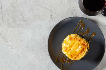 Fried curd pancakes are poured with boiled soft caramel with a mug of aromatic coffee. flat top view healthy breakfast. upper plan, copy space, on a light backgroundの写真素材