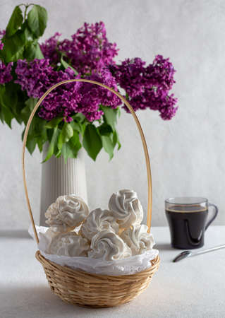 apple marshmallow on a light background in a plate, in the background - a cup of coffee, lilac sprigs.の写真素材