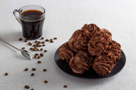 coffee marshmallows on a light background in a plate, in the background is a cup of coffee.の写真素材